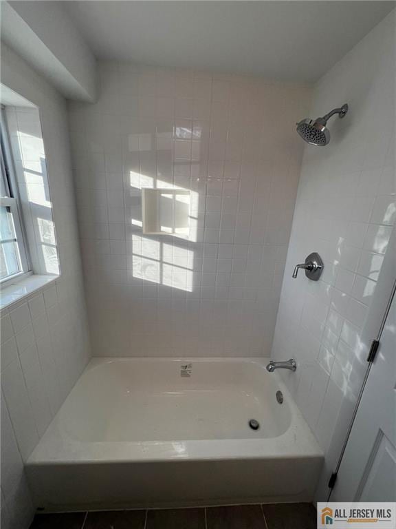 bathroom with washtub / shower combination and tile patterned flooring
