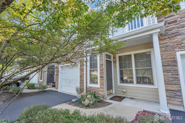 property entrance with stone siding and driveway