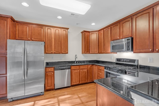 97 Osprey Dr, Old Bridge, NJ 08857 - kitchen with stainless steel appliances, dark stone counters, light wood finished floors, recessed lighting, and brown cabinets