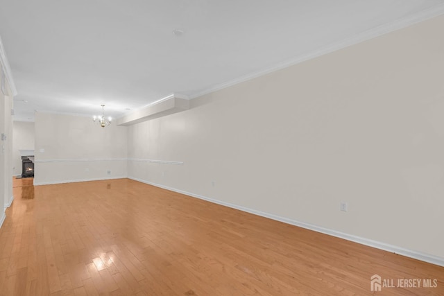 97 Osprey Dr, Old Bridge, NJ 08857 - empty room featuring ornamental molding, light wood-type flooring, a chandelier, and a lit fireplace