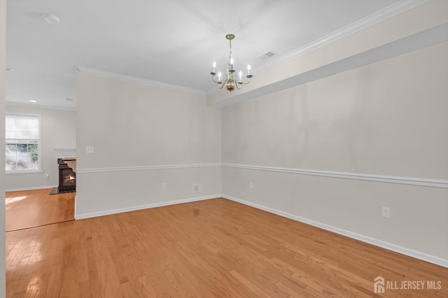 97 Osprey Dr, Old Bridge, NJ 08857 - empty room featuring light wood-type flooring, a chandelier, crown molding, and a smoke detector