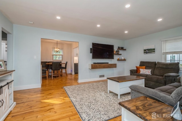 living room featuring light hardwood / wood-style floors and a notable chandelier