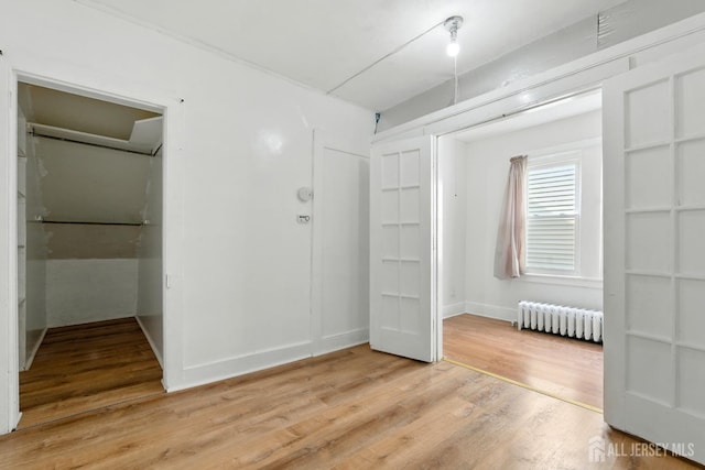 309 1st St, Keyport, NJ 07735 - unfurnished bedroom with light wood finished floors, radiator, and a closet