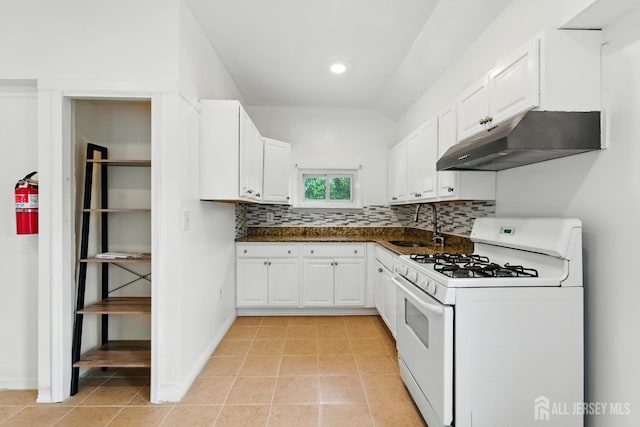 309 1st St, Keyport, NJ 07735 - kitchen with white gas range, under cabinet range hood, dark countertops, decorative backsplash, and white cabinetry