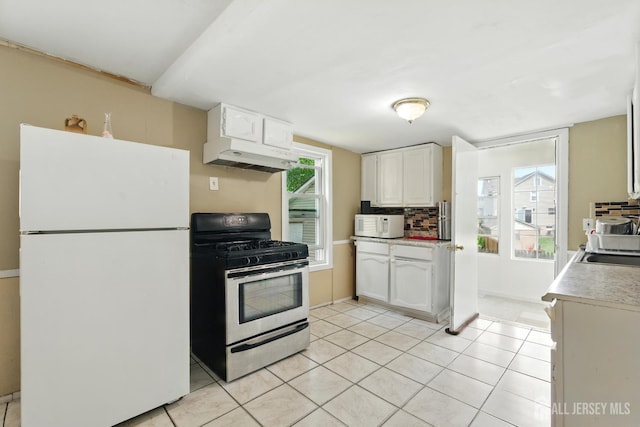 309 1st St, Keyport, NJ 07735 - kitchen featuring white appliances, under cabinet range hood, light countertops, white cabinets, and light tile patterned flooring