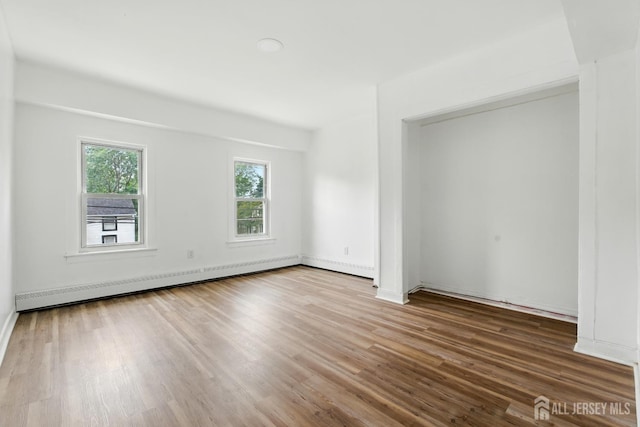 309 1st St, Keyport, NJ 07735 - spare room featuring baseboard heating and wood finished floors