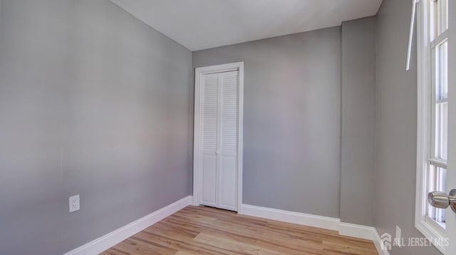 empty room with baseboards and light wood-style floors