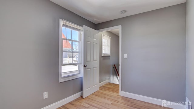 doorway to outside with baseboards and light wood-style flooring