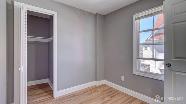 unfurnished bedroom with light wood-style flooring and baseboards