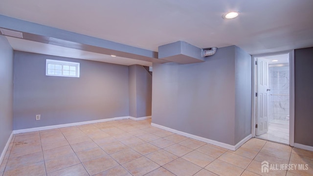 basement with baseboards, light tile patterned flooring, and recessed lighting