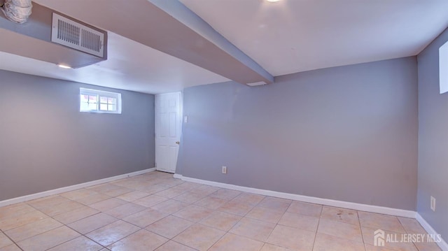 basement with light tile patterned floors, visible vents, and baseboards