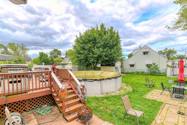 2 Bradley Dr, Edison, NJ 08817 - fenced backyard with a fire pit, a trampoline, a deck, and a patio