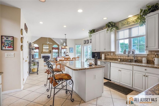 9 Lavender Way E, Brunswick, NJ 08816 - kitchen with stainless steel dishwasher, a breakfast bar, backsplash, light stone countertops, and recessed lighting