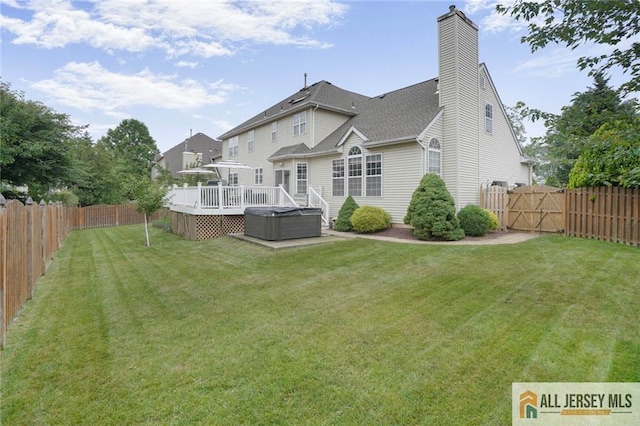 9 Lavender Way E, Brunswick, NJ 08816 - back of house with a deck, a fenced backyard, a hot tub, a gate, and a chimney