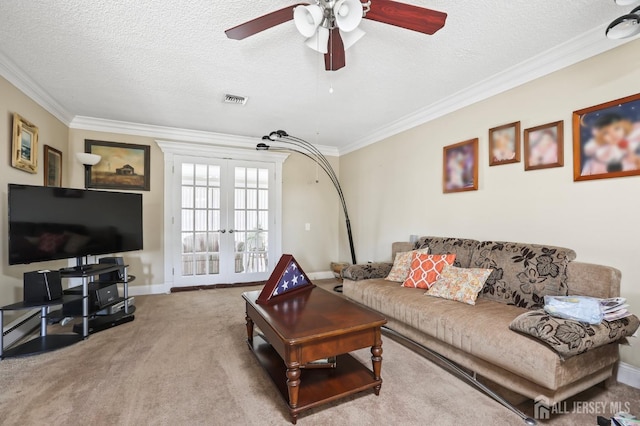 carpeted living room with french doors, ceiling fan, ornamental molding, and a textured ceiling