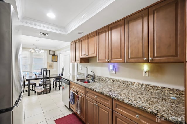 kitchen featuring appliances with stainless steel finishes, stone countertops, sink, light tile patterned floors, and an inviting chandelier