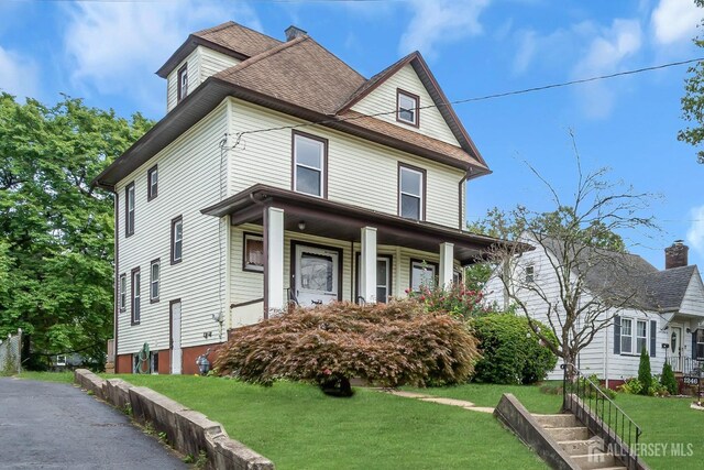 view of front of property with a porch and a front lawn