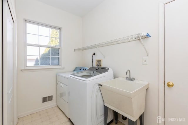 clothes washing area featuring a sink, light floors, laundry area, visible vents, and washer and dryer