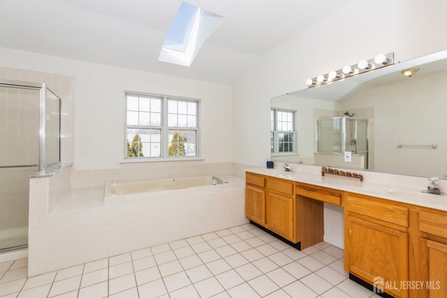 bathroom featuring a stall shower, a sink, a bath, lofted ceiling with skylight, and double vanity