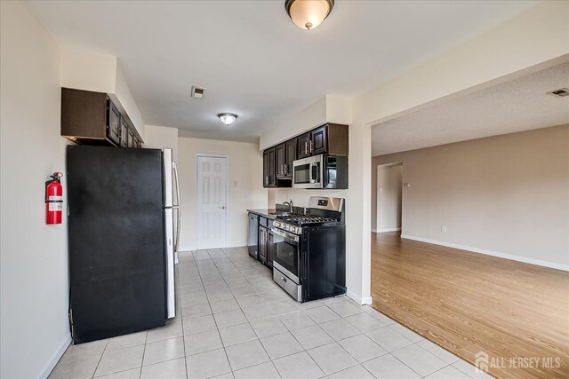 223 Edison Glen Ter, Edison, NJ 08837 - kitchen featuring stainless steel appliances, light tile patterned floors, dark brown cabinets, and open floor plan