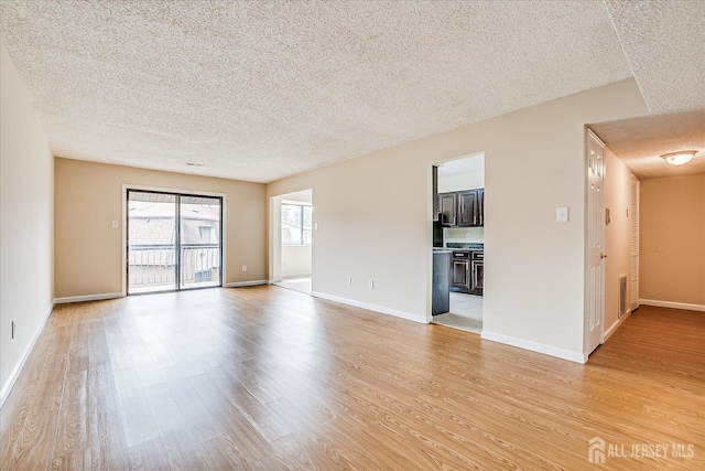 223 Edison Glen Ter, Edison, NJ 08837 - unfurnished living room featuring a textured ceiling and light wood-style floors
