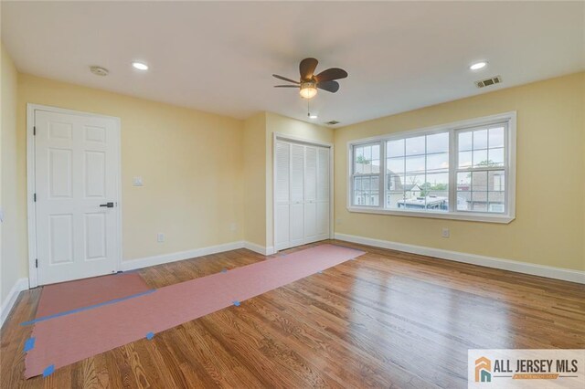 unfurnished bedroom featuring wood finished floors, baseboards, a closet, ceiling fan, and recessed lighting