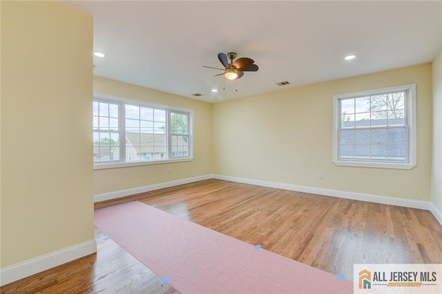 empty room with ceiling fan, wood finished floors, baseboards, and recessed lighting