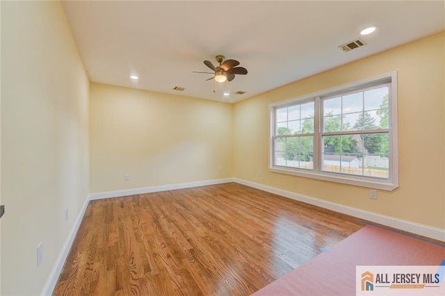 spare room featuring a ceiling fan, wood finished floors, baseboards, and recessed lighting