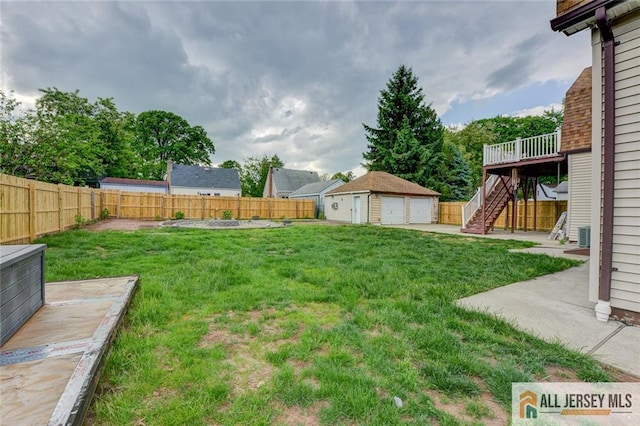 view of yard with stairs, a detached garage, an outdoor structure, a deck, and central AC