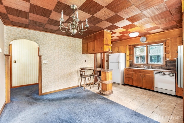 125 Deerfield Rd, Sayreville, NJ 08872 - kitchen with white appliances, arched walkways, a chandelier, open shelves, and brown cabinetry