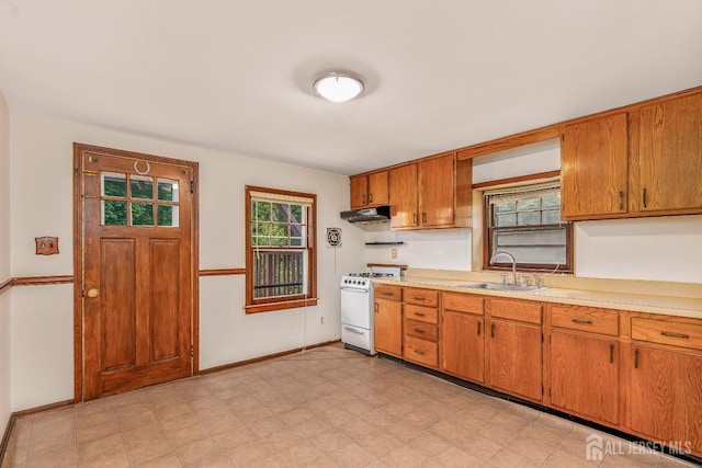 125 Deerfield Rd, Sayreville, NJ 08872 - kitchen featuring white range with gas stovetop, a sink, under cabinet range hood, light countertops, and brown cabinets