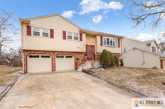 split foyer home with a garage, brick siding, and driveway