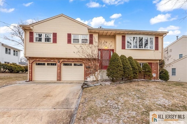 bi-level home with brick siding, driveway, and a garage