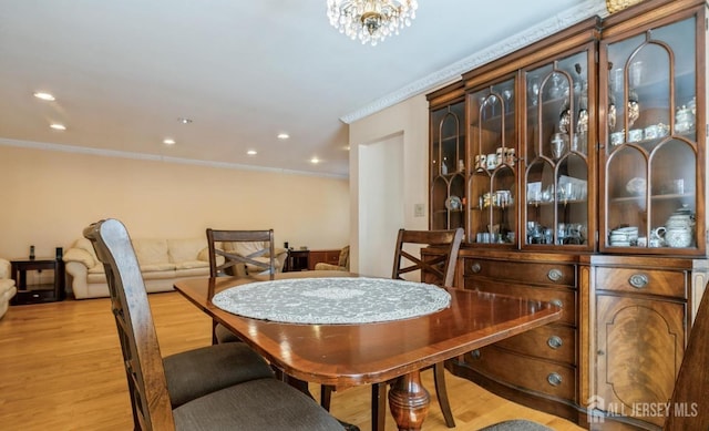 dining area with light wood-type flooring, ornamental molding, and recessed lighting