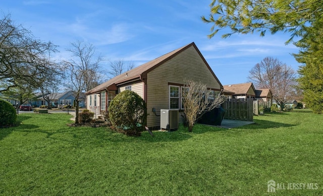 view of side of home with a yard and central AC unit