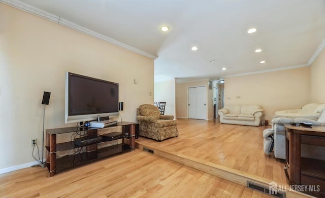 living area with ornamental molding, wood finished floors, baseboards, and recessed lighting