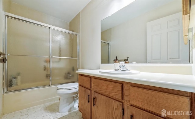 full bathroom featuring shower / bath combination with glass door, vanity, toilet, and tile patterned flooring