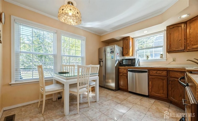 kitchen with stainless steel appliances, plenty of natural light, crown molding, brown cabinets, and light countertops