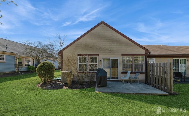 rear view of property featuring a patio area and a yard