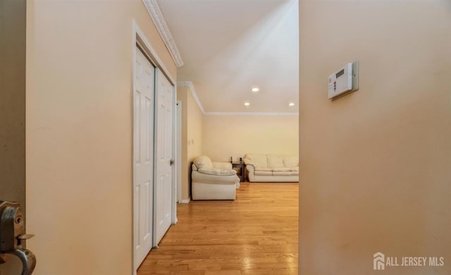 corridor featuring crown molding, light wood-type flooring, and recessed lighting