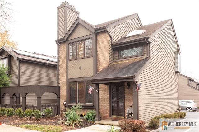 96 Riverbend Dr, North Brunswick, NJ 08902 - view of front of house with brick siding, a chimney, and a shingled roof