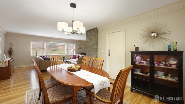 dining room with baseboards, an inviting chandelier, light wood-style floors, and crown molding
