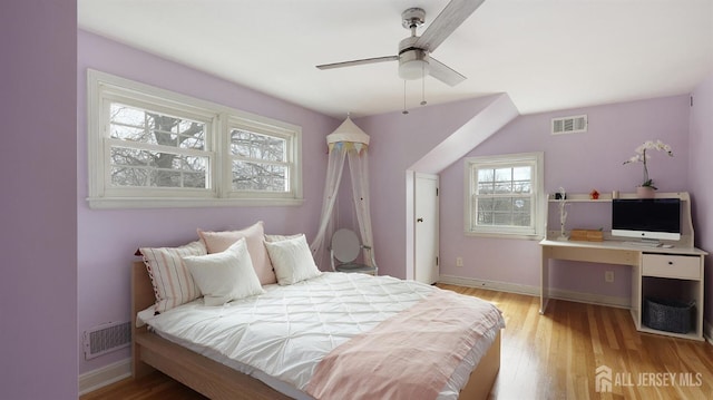 bedroom featuring baseboards, wood finished floors, and visible vents