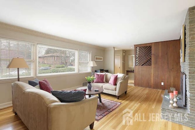 living area with light wood-style flooring, baseboards, and a fireplace