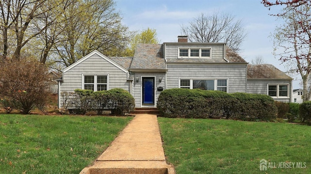 view of front of house featuring a chimney and a front lawn