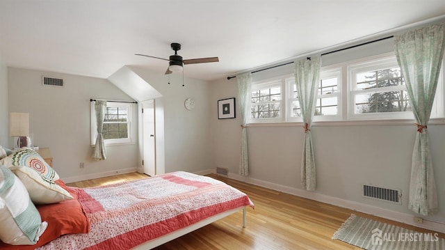 bedroom with wood finished floors, visible vents, and baseboards