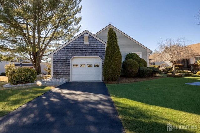 view of front of house with driveway, an attached garage, and a front yard