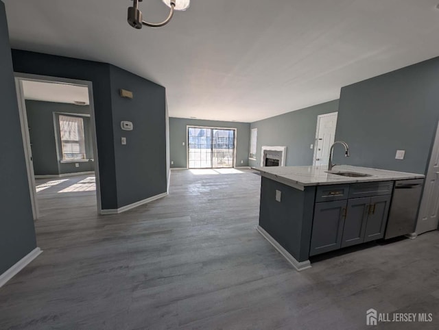 kitchen with a healthy amount of sunlight, open floor plan, a sink, and gray cabinetry