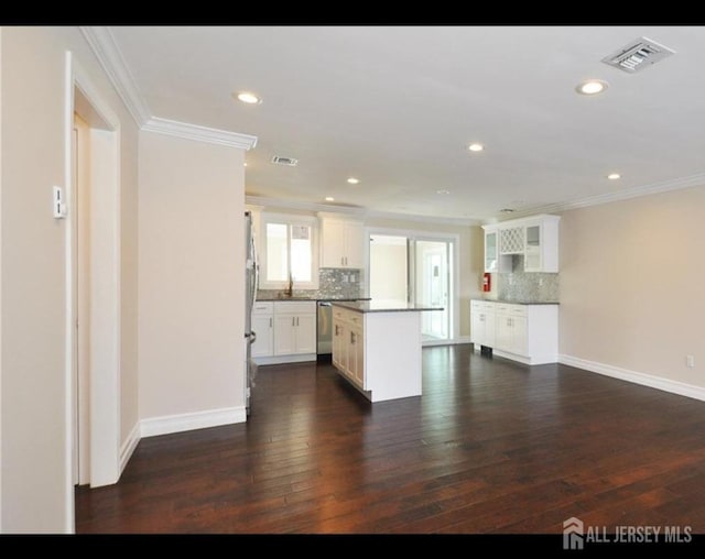17 Celtis Plz Unit B, Monroe, NJ 08831 - kitchen featuring stainless steel dishwasher, ornamental molding, a kitchen island, tasteful backsplash, and dark wood-style flooring