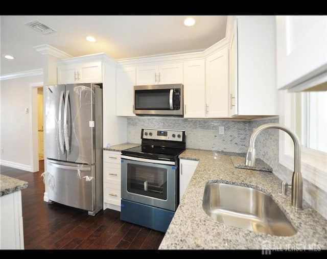 17 Celtis Plz Unit B, Monroe, NJ 08831 - kitchen featuring appliances with stainless steel finishes, crown molding, white cabinets, tasteful backsplash, and light stone counters